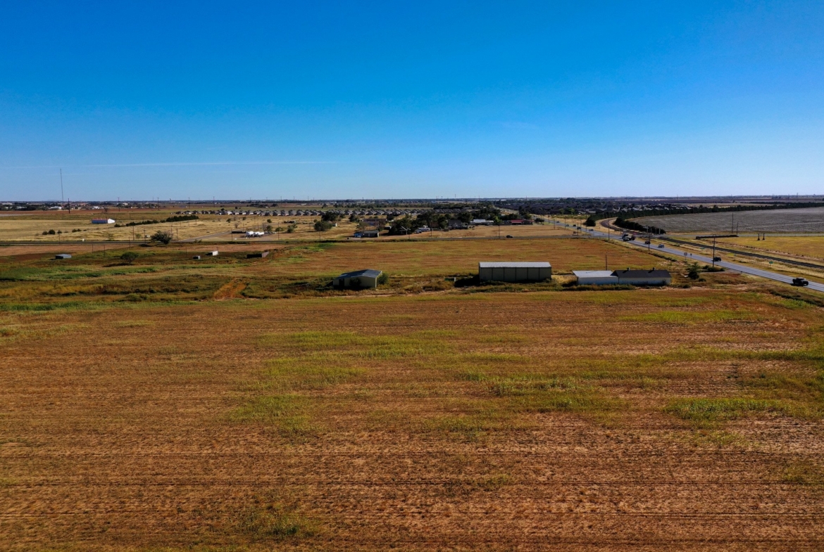 Aerial view across the 3.5 acre corner tract toward 4th Street in Lubbock, TX