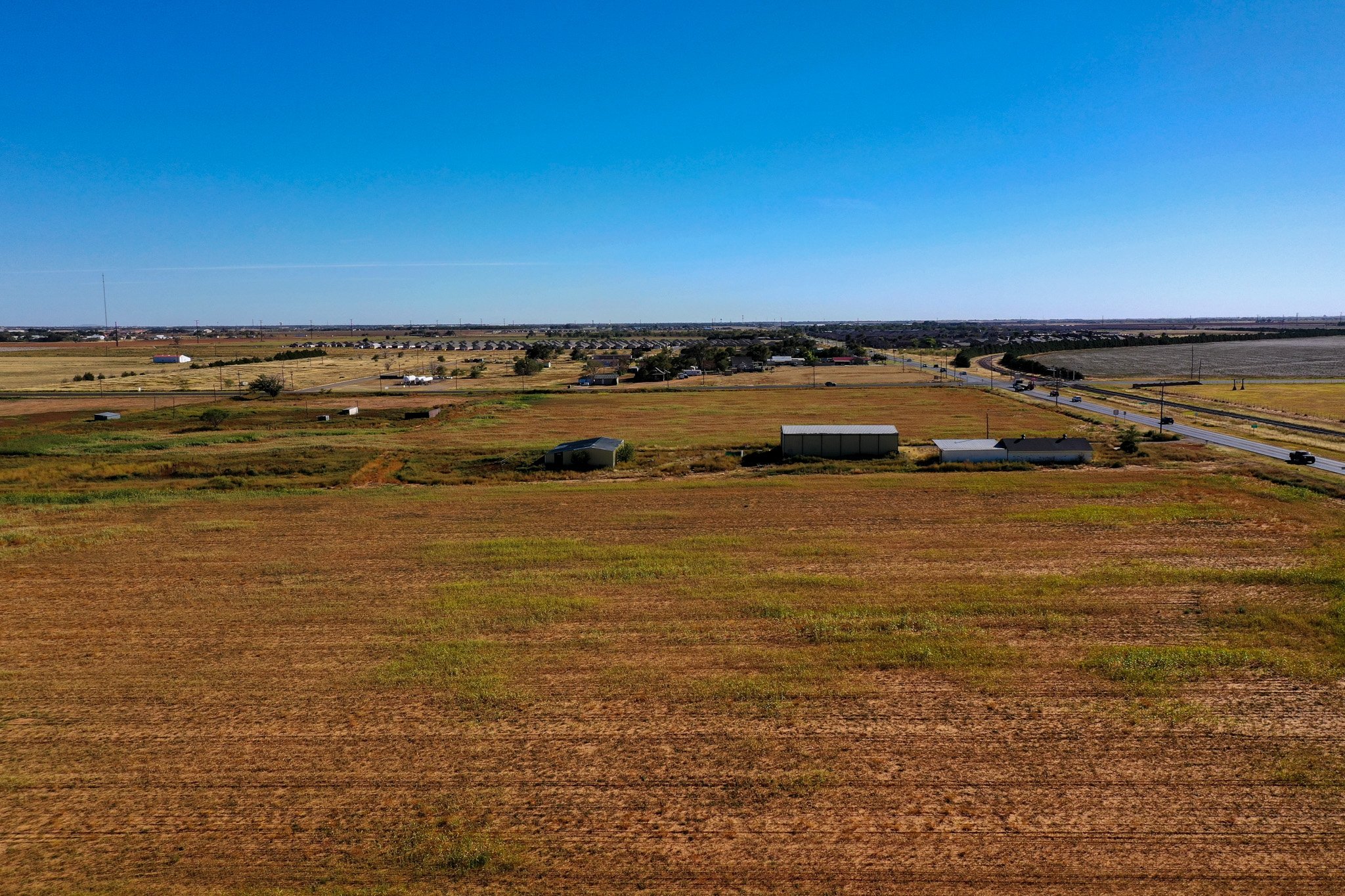 Aerial view across the 3.5 acre corner tract toward 4th Street in Lubbock, TX